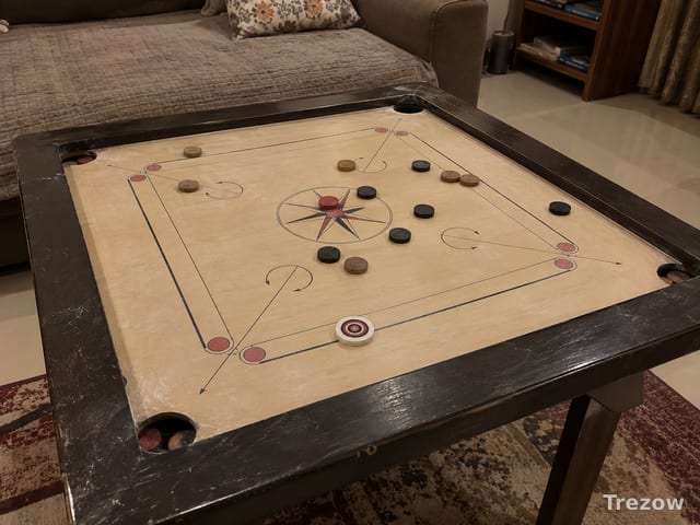 Carrom board with coins and striker